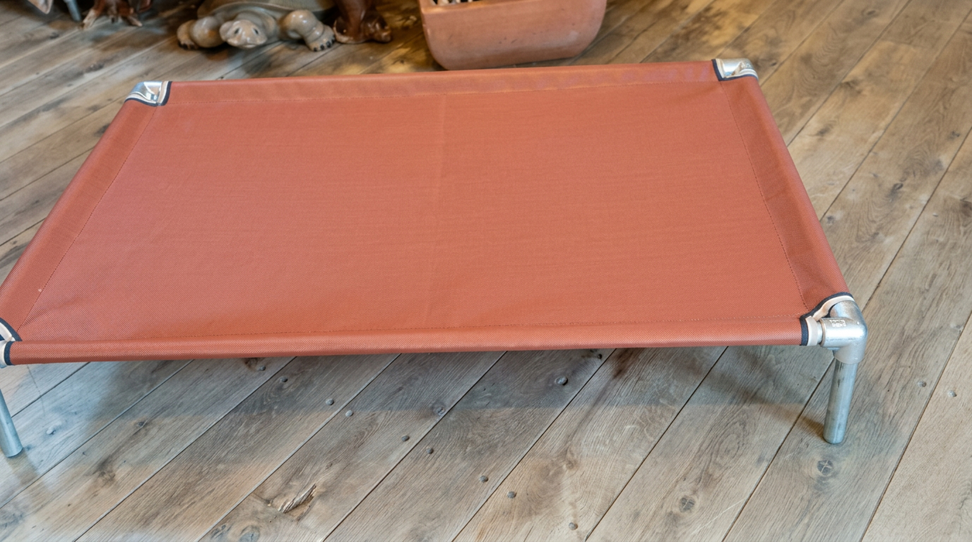 Rust KosieCare bed on a wood floor